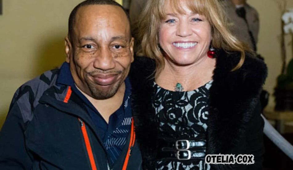 Otelia Cox smiling at a community event, standing beside Tony Cox.


