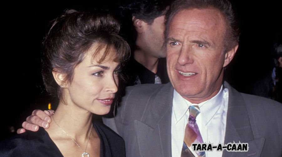 Tara A. Caan at a red carpet event in a black gown, smiling.
